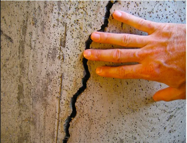 Worker assessing concrete crack width and depth with measuring tools on site