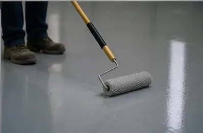 Worker rolling spiked roller across self-levelling epoxy floor