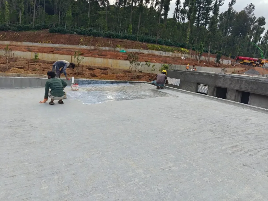 Worker rolling a textured protective topcoat onto a terrace surface
