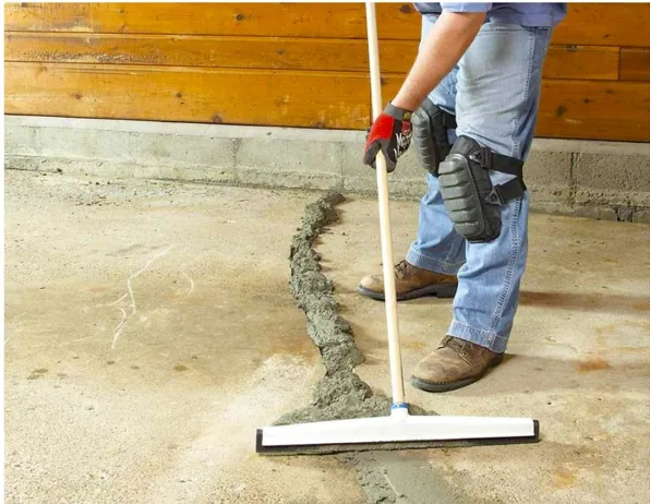 Worker leveling and smoothing the finished concrete repair mortar